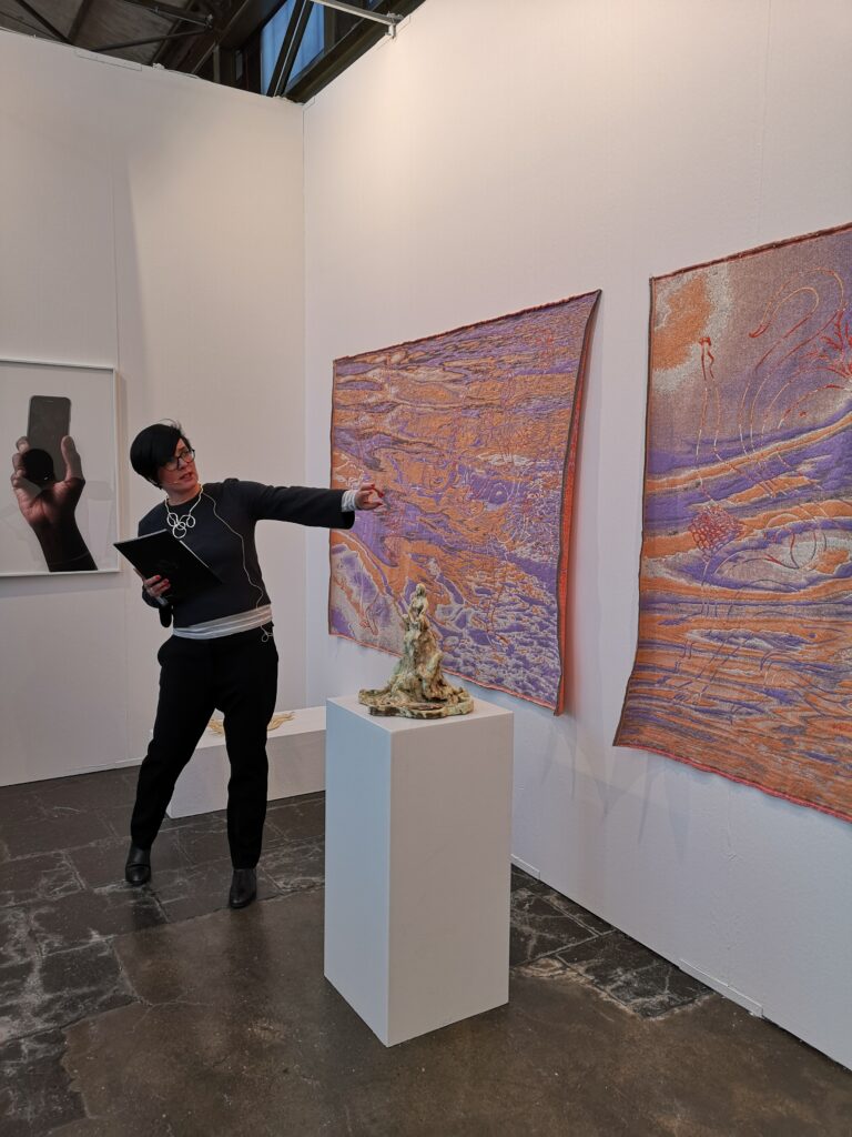 Agnieszka Mese erklärt während einer Führung auf der Kunstmesse ART DÜSSELDORF 2018 Tapisserien von Agnieszka Brzezynska